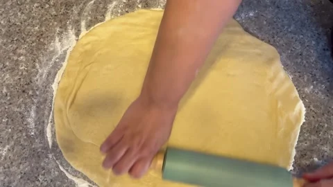 Rolling Out Dough with a Pin on a Floured Countertop Stock Footage 345522391