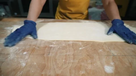 Rolling out the dough with a rolling pin. The process of home baking from wheat Stock Footage 256108498