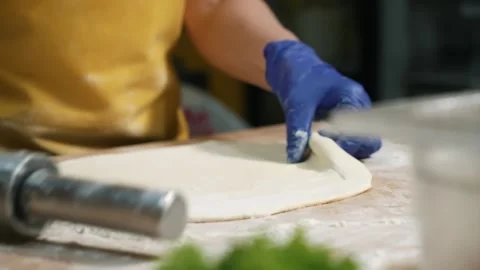 Rolling out the dough with a rolling pin. The process of home baking from wheat Stock Footage 261089847