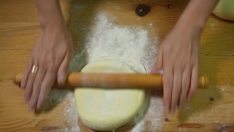 Rolling out the dough with a rolling pin for further preparation of dumplings Stock Footage 317038420