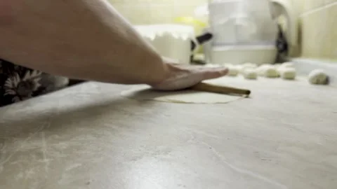 Rolling out dough with wooden rolling pin on domestic kitchen counter Stock Footage 337669664
