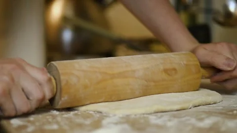 Rolling out dough with wooden rolling pin close up Stock Footage 340078094