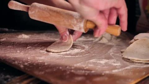 Rolling out dumpling wrappers on a wooden board Stock Footage 288047885