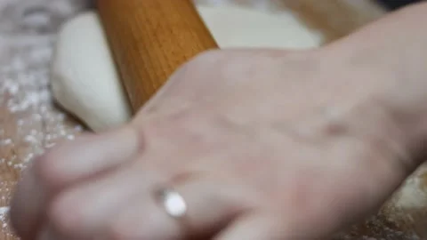 Rolling out fresh dough for tuna pizza on wooden cutting board. Preparing heart Stock Footage 146924424