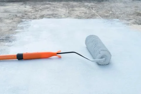 Rolling paint brush that is placed on a gray area. 写真素材