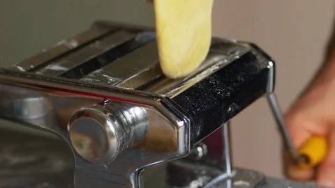 Rolling pasta dough in a pasta machine Stock Footage 71236031