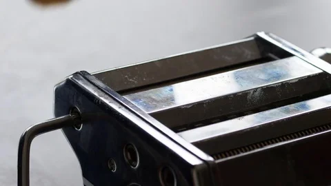 Rolling pasta dough in a pasta machine Stock Footage 71236689