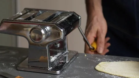 Rolling pasta dough in a pasta machine Stock Footage 71236849