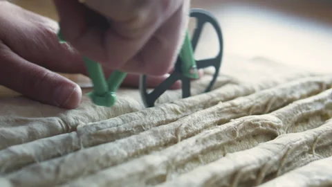 Rolling pastry cutter to slice rolled dough into even strips. Stock Footage 331851488