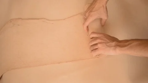 Rolling in a piece of raw vegetable tanned leather hide Stock Footage 126115534