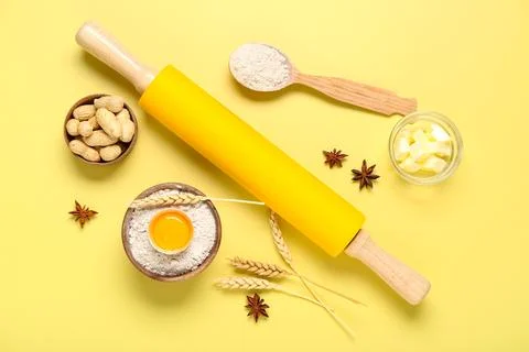 Rolling pin and ingredients for baking on yellow background Stock Photos