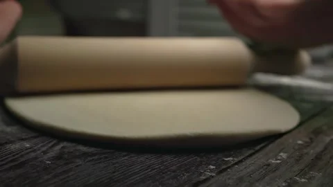 Rolling pin close-up, rolling pizza dough view from a person. Stock Footage 240850731