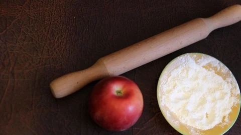 Rolling pin with flour and an apple on the table Video stock 101466806
