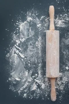 Rolling pin with flour on a dark table. Chicken background. Cooking. Bakery Stock Photos