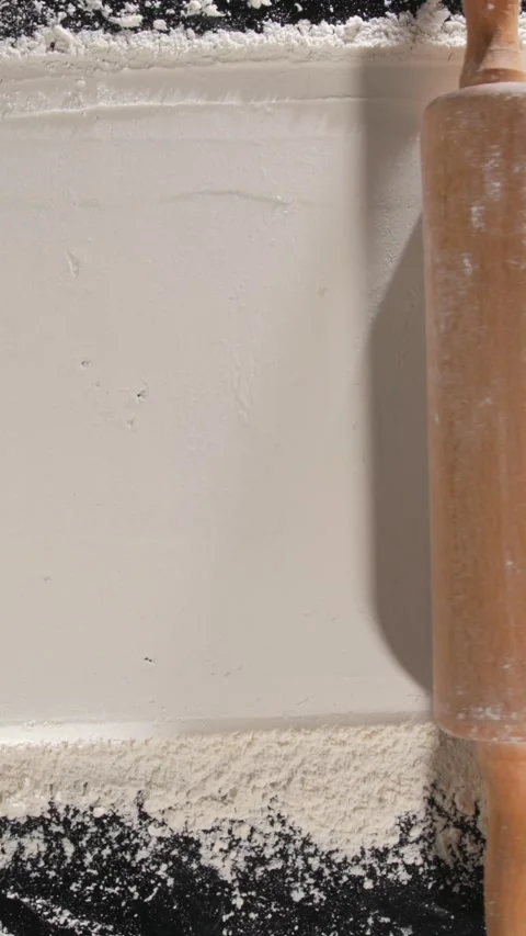 Rolling pin moving through flour across frame baking process Stock Footage 332234930