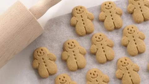 Rolling pin resting near gingerbread cookies on parchment creates warm Christmas Stock-Footage 323178405