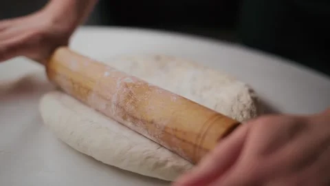 Rolling pin shapes dough on clean countertop Stock Footage 336049825
