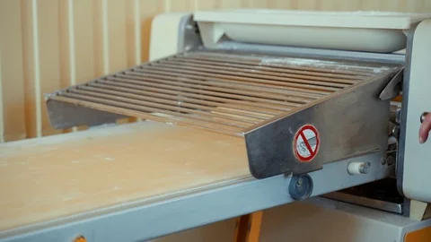 Rolling puff pastry on a machine for making pies and rolls. Stock Footage 128240146
