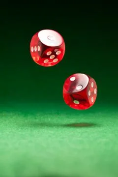 Rolling red dice on a casino table Stock Photos
