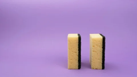 Rolling round sponge for washing dishes on a purple background. Stockbeeldmateriaal 127694952