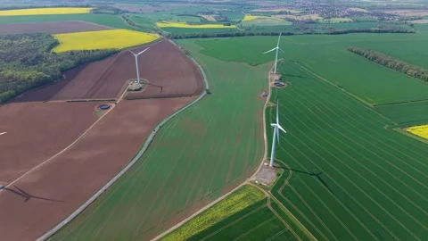 Rolling rural fields leading to hilltop wind turbines, forward drone flight in Stock Footage 346653320