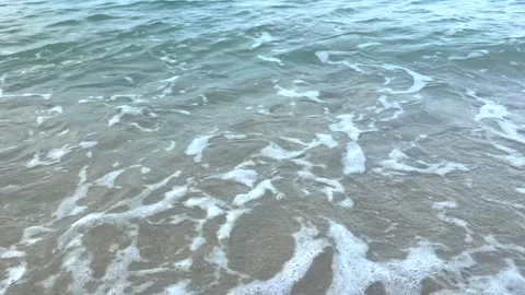 Rolling sea wave reaching sandy beach with sparkling water and white foam Stock Footage 337104934