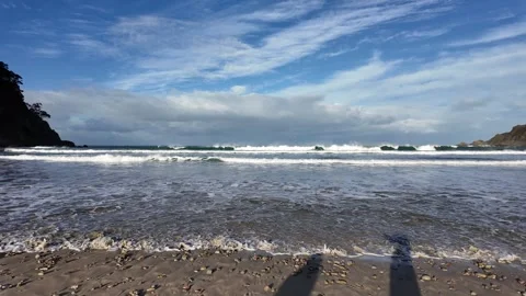 Rolling sea waves breaking along remote tropical shoreline beneath dramatic Video stock 333364107