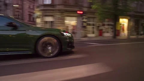 Rolling shot of Audi RS5 luxury coupe sport car driving on street at night Stock Footage 261381908