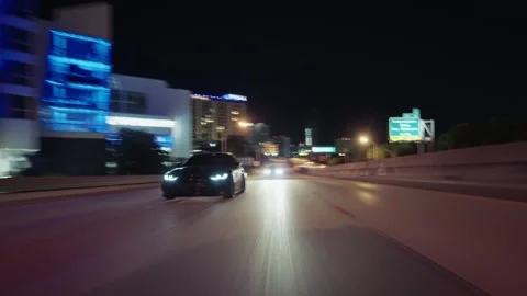 Rolling shot of black bmw luxury car driving fast on a miami highway at night Vídeos de archivo 341956471
