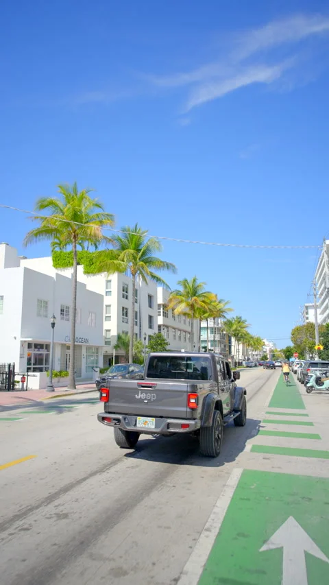 Rolling shot Jeep Gladiator driving Miami Beach Ocean Drive vertical 4k 60p Stock Footage 329447141