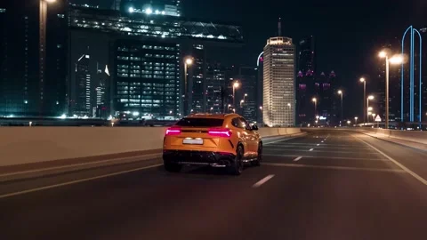 Rolling shot of Lamborghini Urus SUV car driving on street at night in Dubai UAE Video stock 200032458