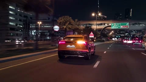 Rolling shot of Lamborghini Urus SUV car driving on street at night in Dubai UAE Stock-Footage 200032477