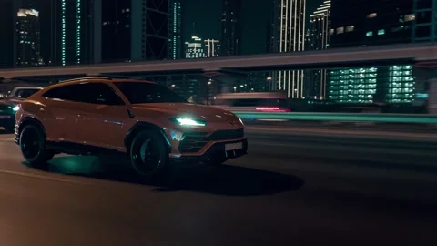 Rolling shot of Lamborghini Urus SUV car driving on street at night in Dubai UAE Video stock 200032601