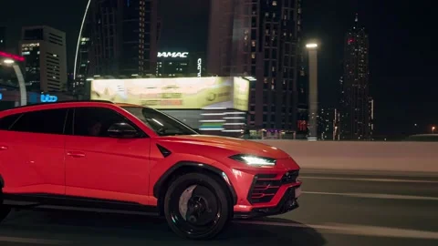 Rolling shot of Lamborghini Urus SUV car driving on street at night in Dubai UAE Stock-Footage 200032602
