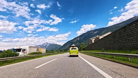 Rolling shot of an old van driving on a mountain highway with Swiss Alps view Stock Footage 301548685
