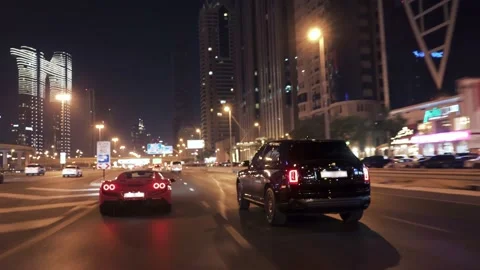 Rolling shot of Red Ferrari and Rolls Royce Cullinan car driving in Dubai Video stock 200033499
