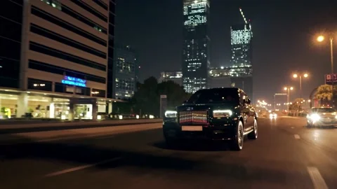 Rolling shot of Rolls Roys Cullinan car driving on the street at night in Dubai Video stock 200033456