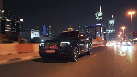 Rolling shot of Rolls Roys Cullinan car driving on the street at night in Dubai Video stock 200033534