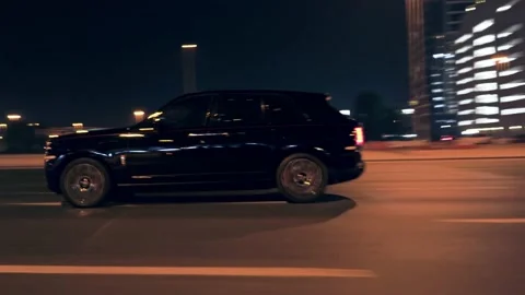 Rolling shot of Rolls Roys Cullinan car driving on the street at night in Dubai Video stock 200033804
