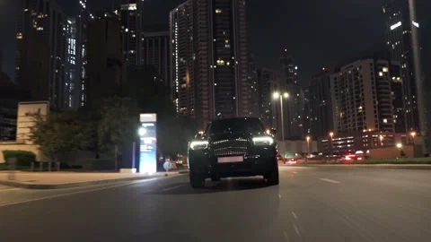 Rolling shot of Rolls Roys Cullinan car driving on the street at night in Dubai Stock Footage 200033913