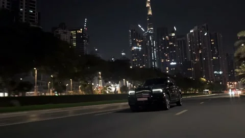 Rolling shot of Rolls Roys Cullinan car driving on the street at night in Dubai Stock Footage 200033956