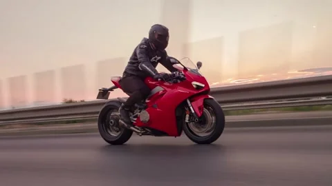 Rolling shot of two men bikers riding motorcycles on the highway at sunset Stock Footage 214081244
