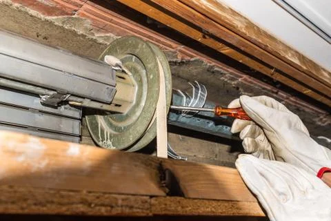 Rolling shutter repair. Worker adjusts a broken roller shutter of a home Stock Photos