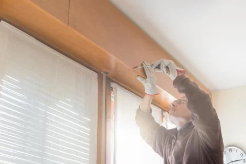 Rolling shutter repairer is opening the box containing the broken shutter Stock Photos