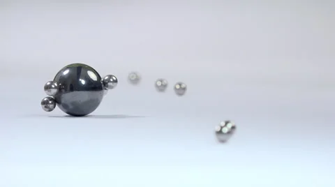 Rolling small metallic marbles attracted by magnetic ball  - close up Stock Footage 58154038