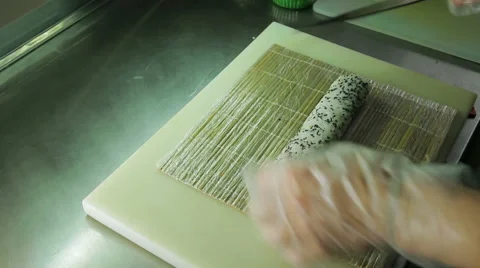 Rolling up the sushi roll with bamboo mat, upside view Stock Footage 41960663