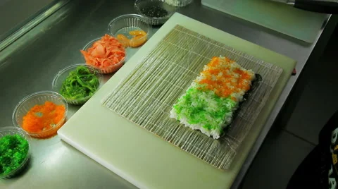 Rolling up the sushi roll with red and green tobiko, upside view Stock Footage 41966975