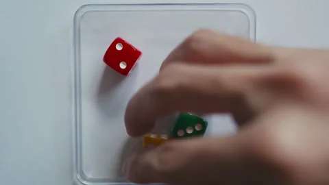 Rolling Three Red Yellow and Green Dice on Transparent Square Tray Stock Footage 331915368