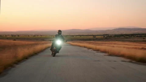 Rolling Tracking Shot of Adventure Scrambler Motorcycle on Rural Road at Dusk Video stock 323553986