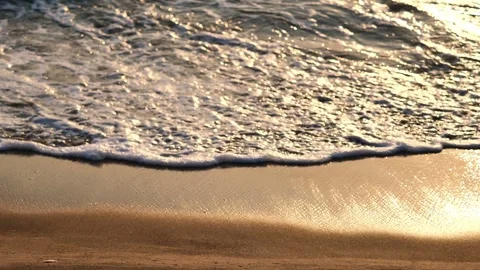 Rolling wave on golden sand at sunset Stock Footage 265232420